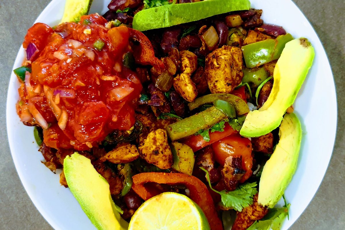 A plate of chicken, peppers and avocado